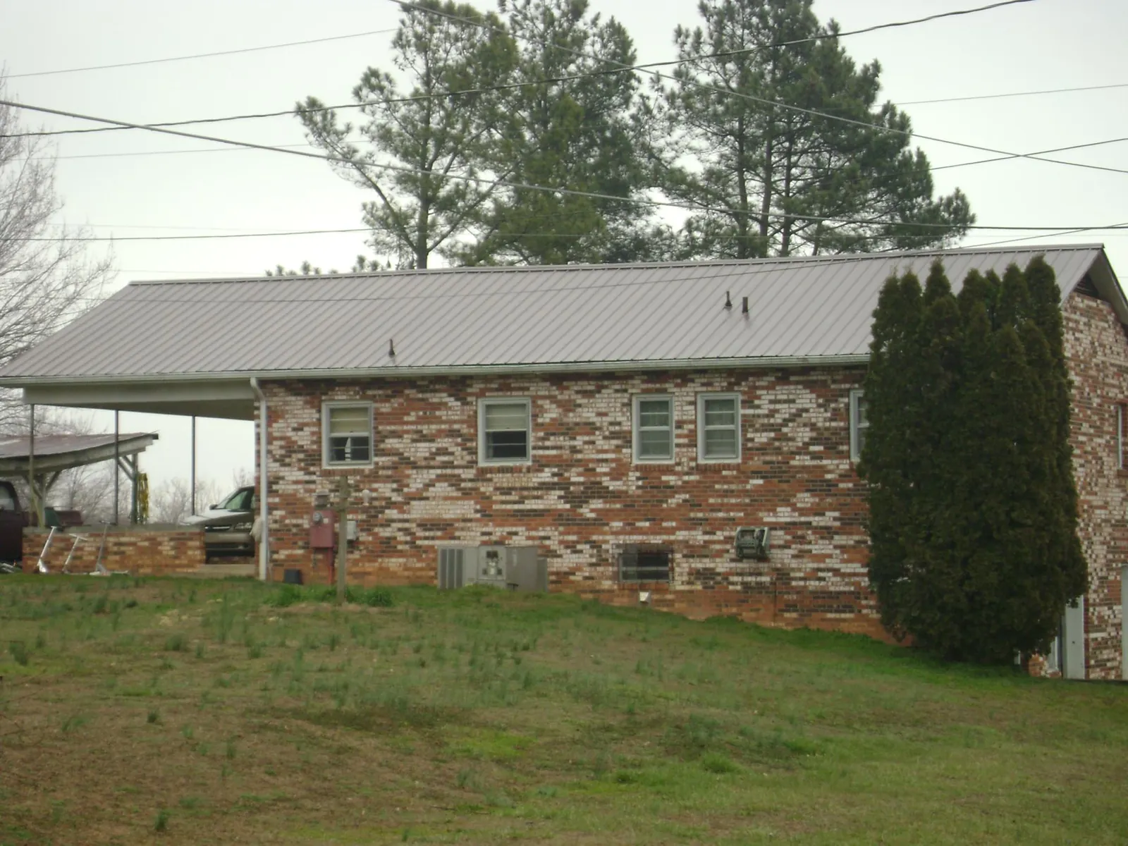 Gray metal roof on a brick split level home with a carport in Fremont